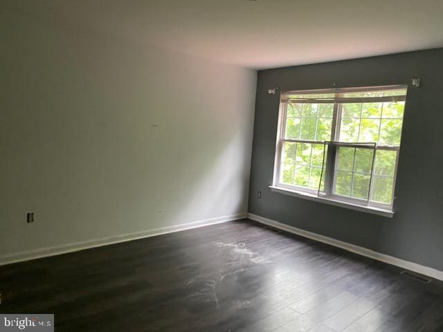 unfurnished room with dark hardwood / wood-style floors