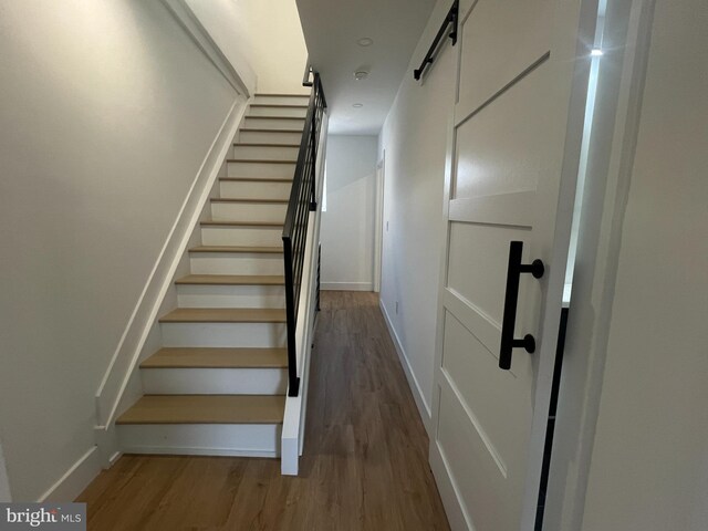 stairs featuring wood-type flooring and a barn door