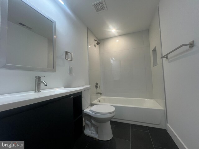 full bathroom featuring tile patterned floors, vanity, toilet, and tiled shower / bath combo