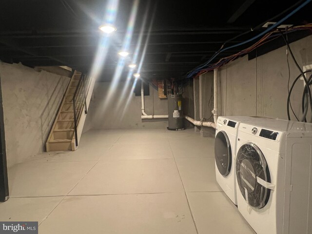 basement featuring electric water heater and washer and dryer