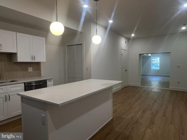 kitchen with white cabinets, decorative light fixtures, and stainless steel dishwasher