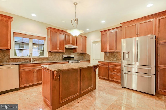 kitchen featuring pendant lighting, light stone counters, a center island, sink, and appliances with stainless steel finishes