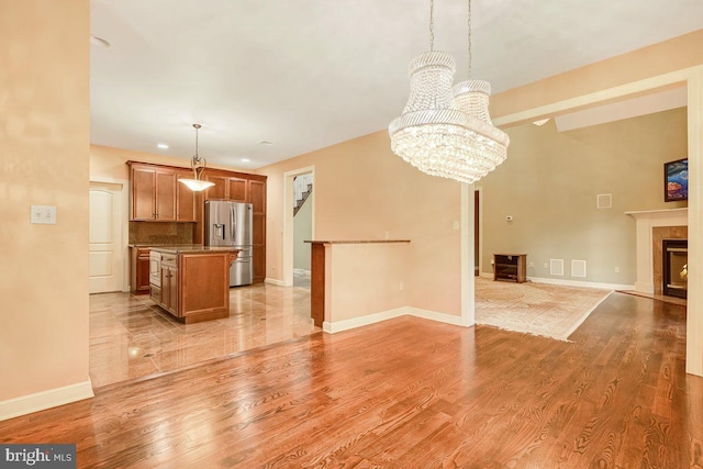 unfurnished living room with light hardwood / wood-style flooring and a chandelier