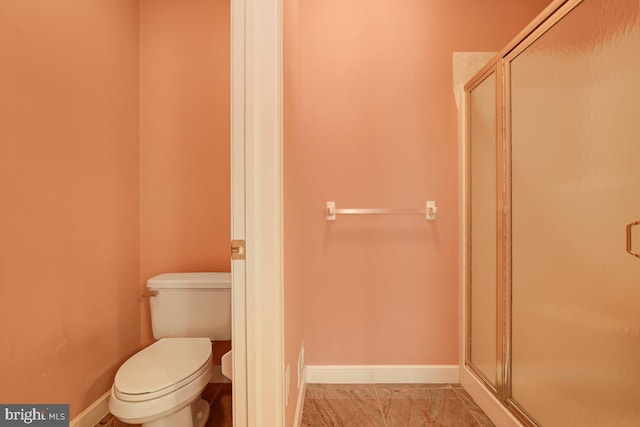 bathroom featuring toilet, tile patterned floors, and an enclosed shower