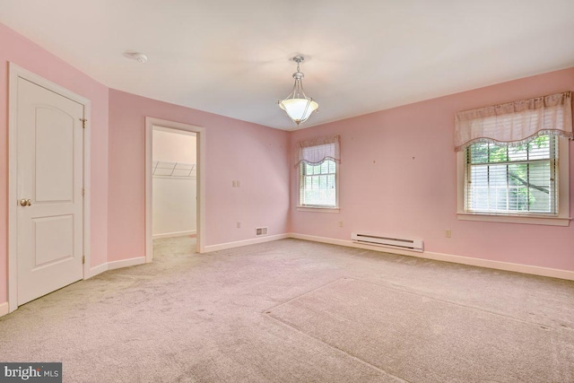 empty room with light colored carpet and a baseboard radiator