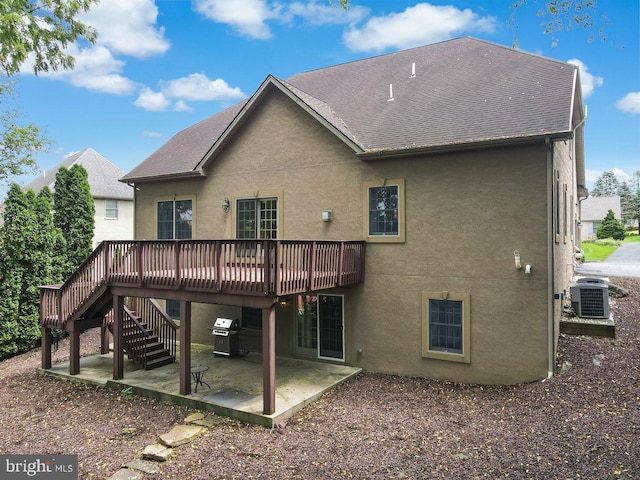 rear view of property featuring central AC unit, a deck, and a patio