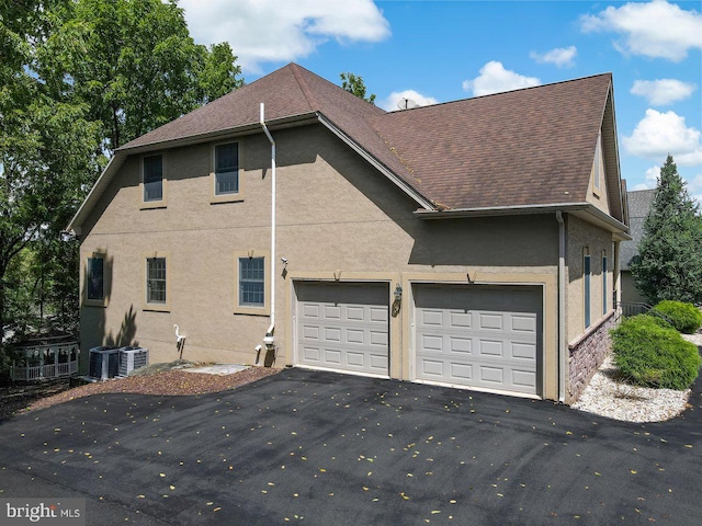 view of home's exterior featuring a garage and central AC unit