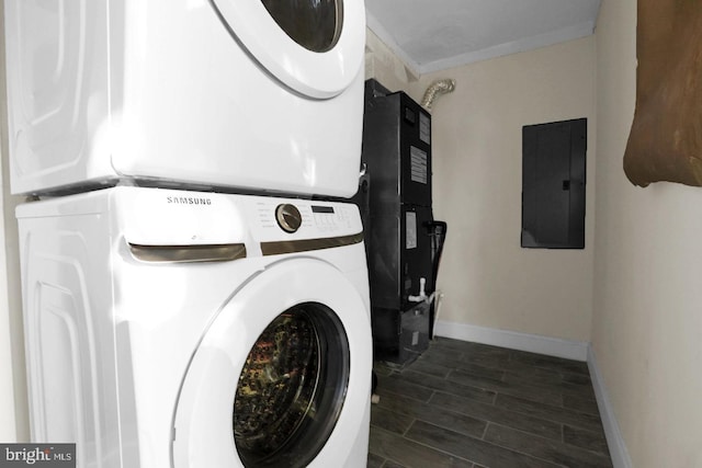 washroom featuring dark hardwood / wood-style flooring, stacked washer and clothes dryer, electric panel, and ornamental molding