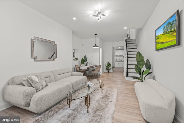 living room with a notable chandelier and light wood-type flooring