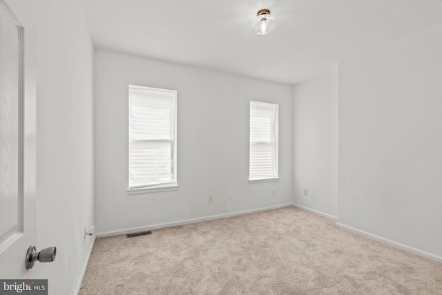 carpeted empty room featuring a wealth of natural light