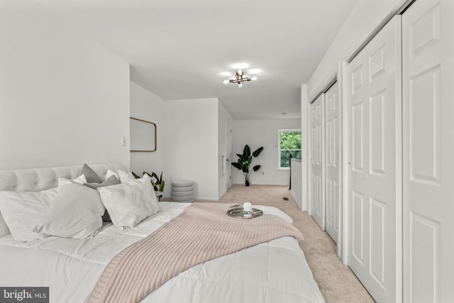 bedroom with light colored carpet and multiple closets