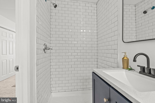 bathroom with a tile shower and vanity