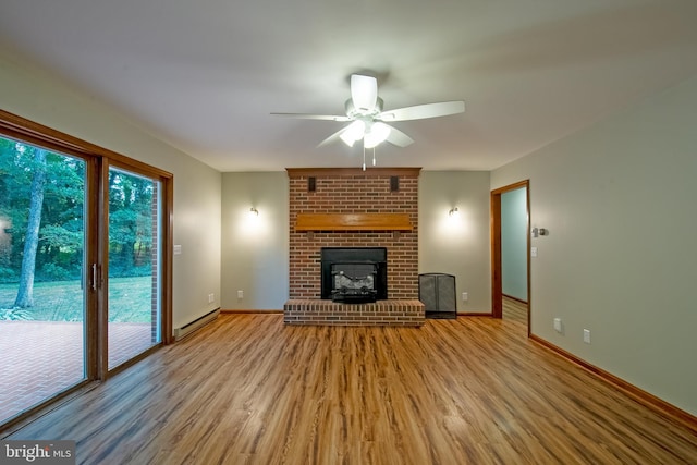 unfurnished living room with light hardwood / wood-style flooring, baseboard heating, ceiling fan, and a brick fireplace