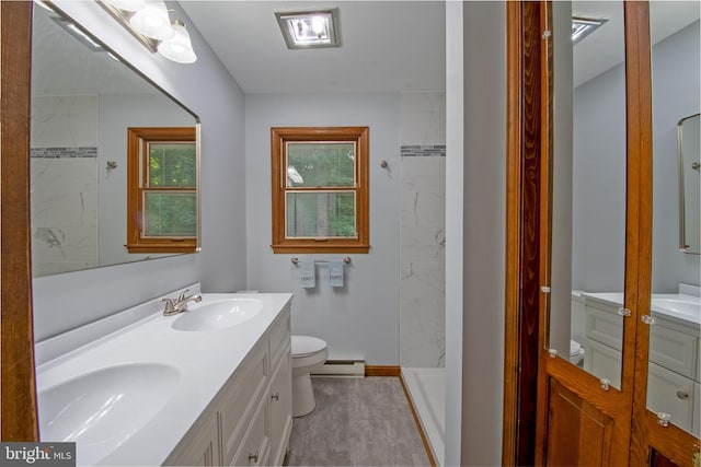 bathroom with a baseboard radiator, a tile shower, vanity, and toilet