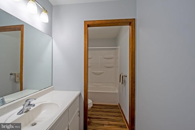 full bathroom with bathing tub / shower combination, vanity, toilet, and wood-type flooring