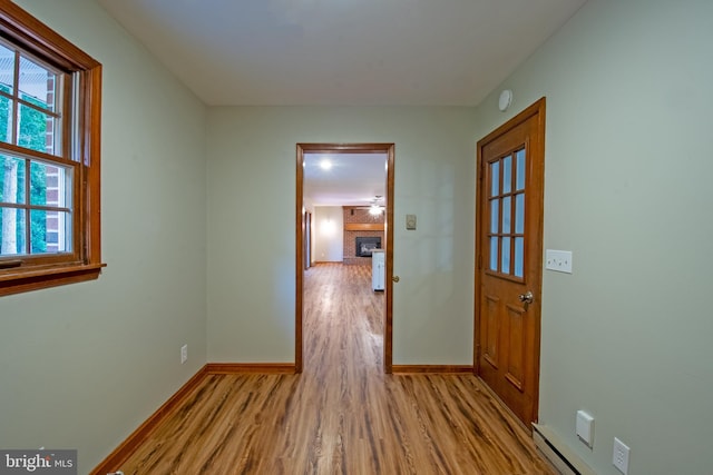 corridor featuring a baseboard radiator and light hardwood / wood-style flooring