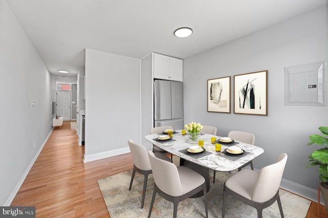 dining space with light wood-type flooring and electric panel