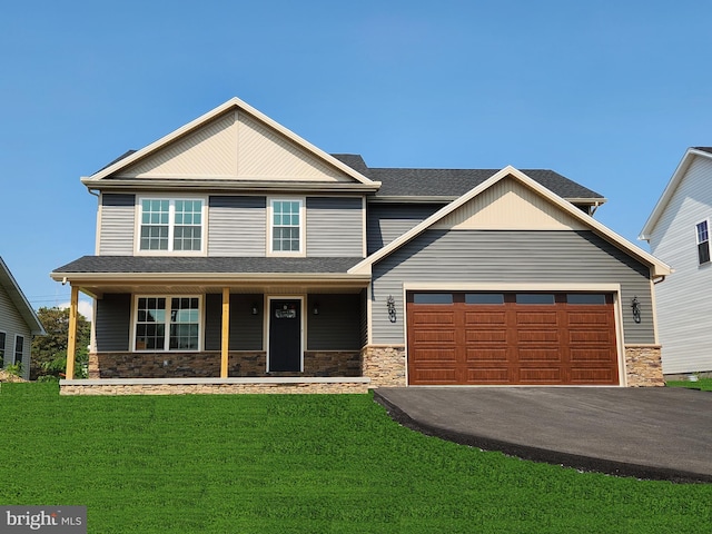 craftsman-style home with a garage, covered porch, and a front yard