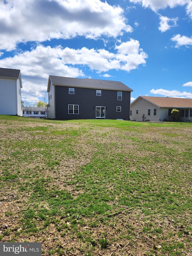 rear view of property featuring a lawn