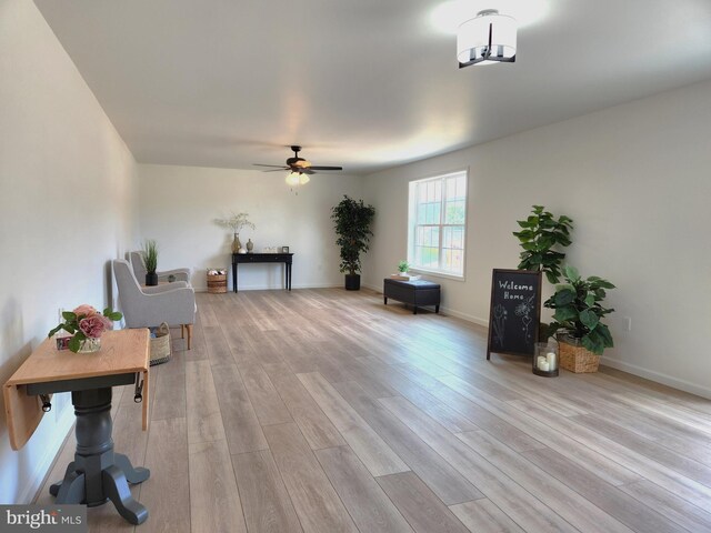 sitting room with light wood-type flooring and ceiling fan