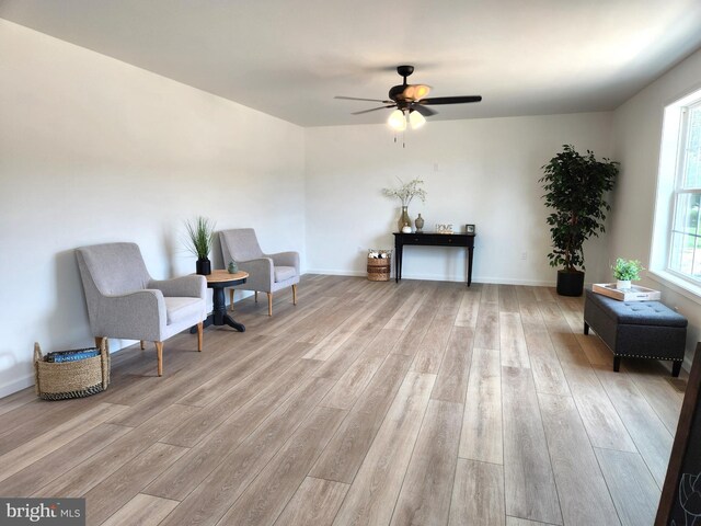 living area with light hardwood / wood-style floors and ceiling fan