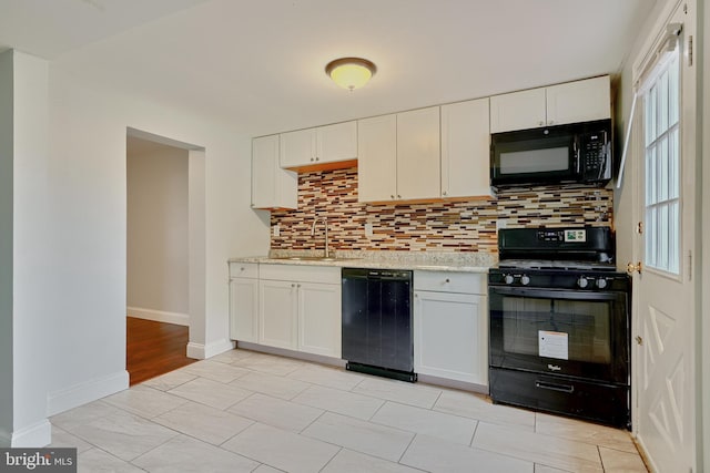 kitchen with white cabinets, black appliances, tasteful backsplash, and sink