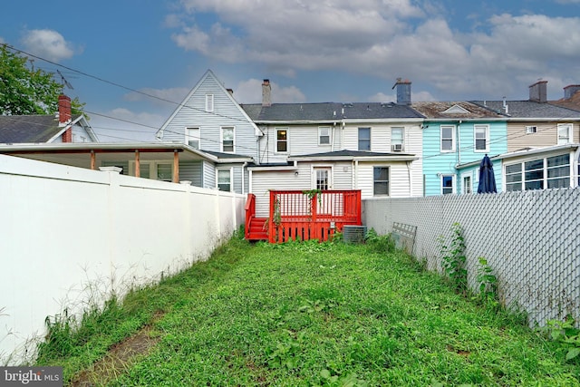 back of house featuring a wooden deck, central air condition unit, and a yard