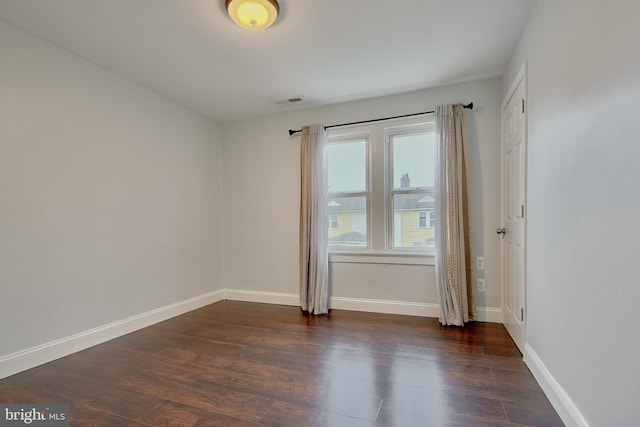 unfurnished room with dark hardwood / wood-style flooring