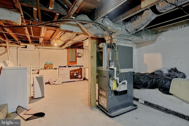 basement with heating unit, electric panel, and washer and dryer