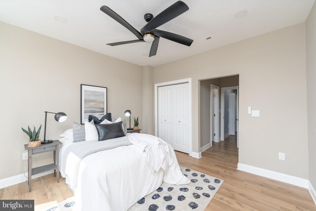 bedroom with ceiling fan, a closet, and light hardwood / wood-style floors