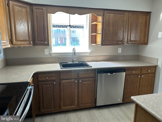 kitchen featuring dishwasher, sink, and light hardwood / wood-style floors