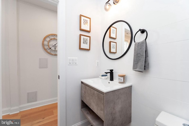 bathroom with vanity, toilet, and hardwood / wood-style floors