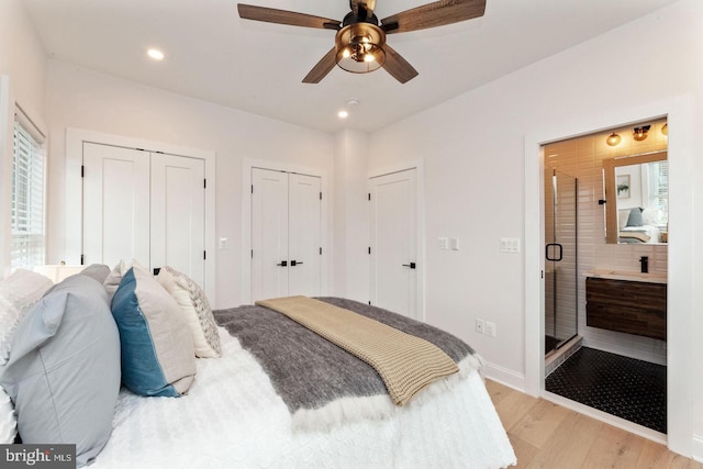 bedroom featuring light wood-type flooring, ceiling fan, and multiple closets