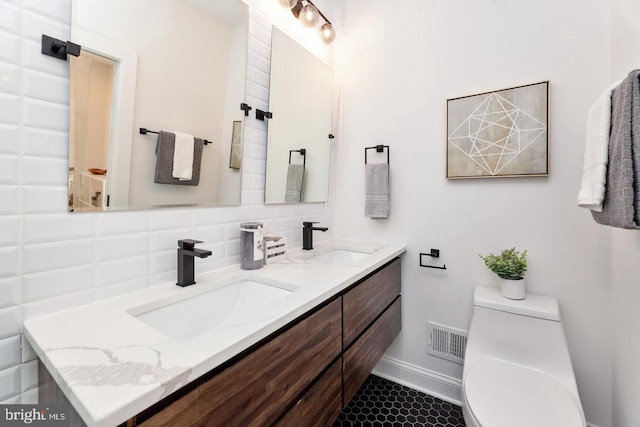 bathroom featuring vanity, toilet, backsplash, and tile patterned flooring