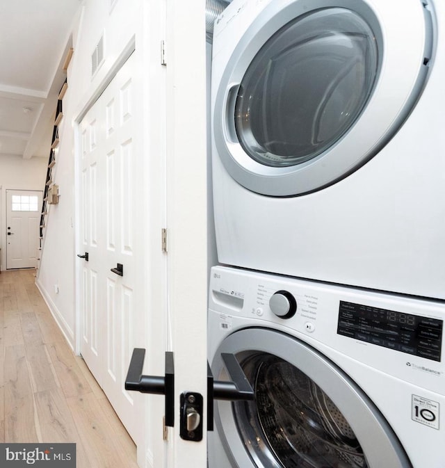 laundry area featuring light hardwood / wood-style flooring and stacked washer and dryer