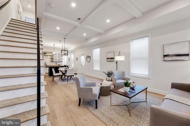 living room with beamed ceiling, a healthy amount of sunlight, and light hardwood / wood-style floors