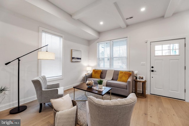 living room featuring light wood-type flooring and beamed ceiling