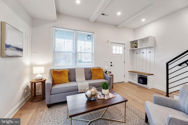 living room with light wood-type flooring and beamed ceiling