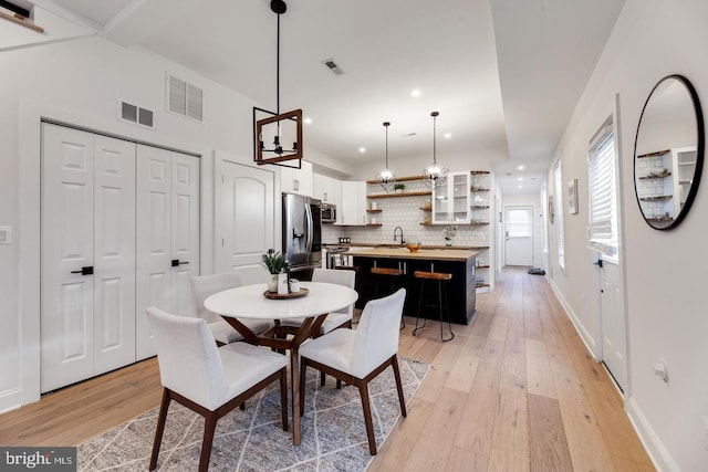 dining area with sink and light hardwood / wood-style floors