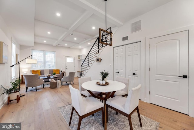 dining room featuring coffered ceiling, light hardwood / wood-style floors, and beam ceiling