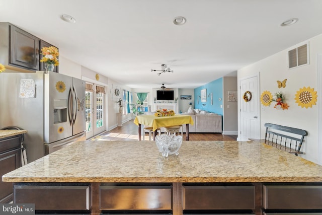 kitchen featuring french doors, light wood-type flooring, dark brown cabinets, and stainless steel refrigerator with ice dispenser