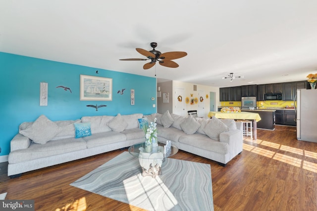 living room featuring ceiling fan and dark hardwood / wood-style floors