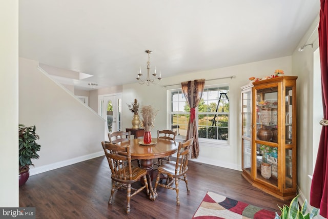 dining room with dark hardwood / wood-style floors and an inviting chandelier