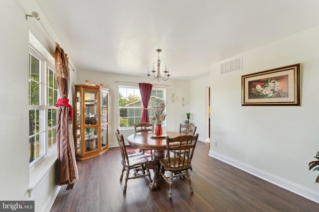 dining area with dark wood-type flooring and a chandelier