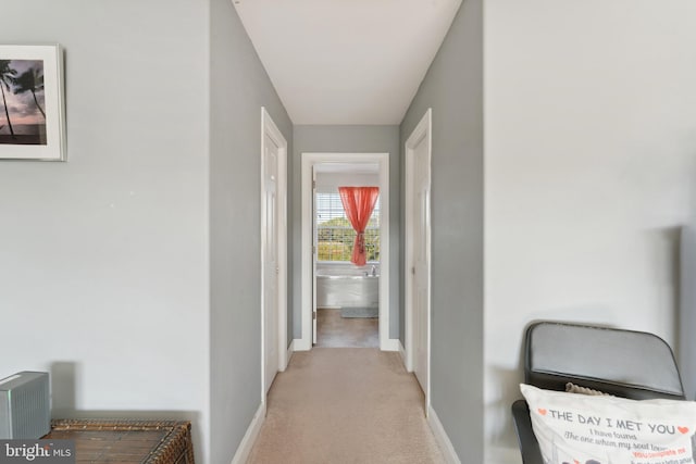 hallway featuring light colored carpet