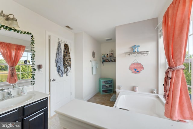 bathroom featuring a washtub and vanity