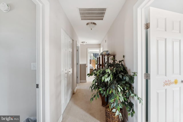 hall with light colored carpet