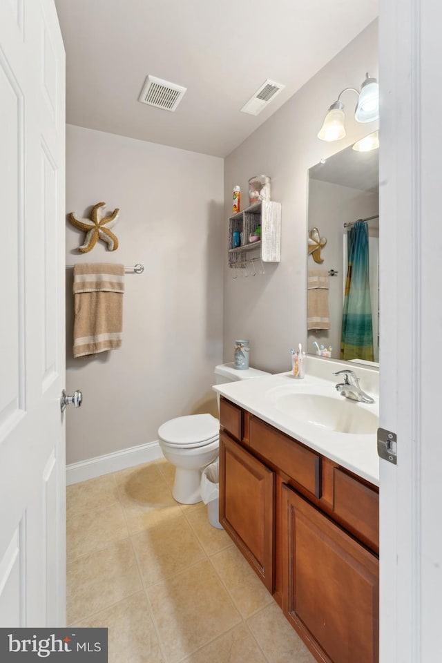 bathroom featuring tile patterned flooring, vanity, toilet, and walk in shower