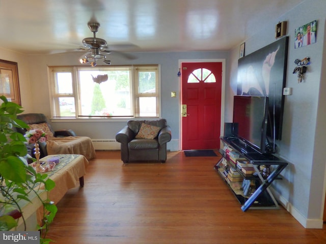 living room featuring wood-type flooring, baseboard heating, and ceiling fan