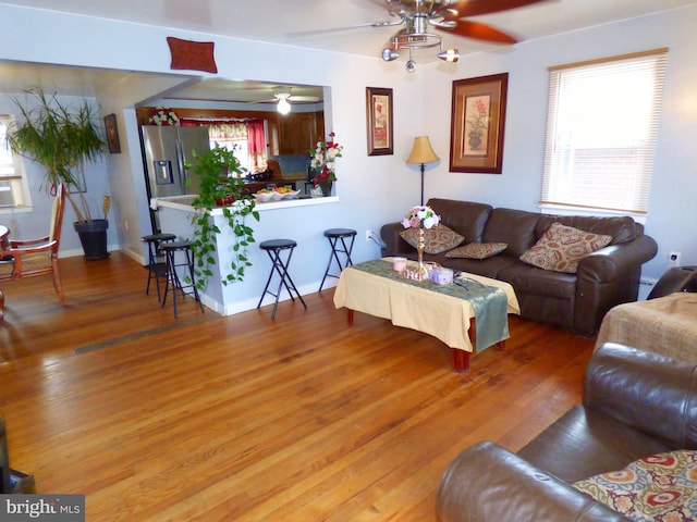 living room featuring ceiling fan and hardwood / wood-style flooring